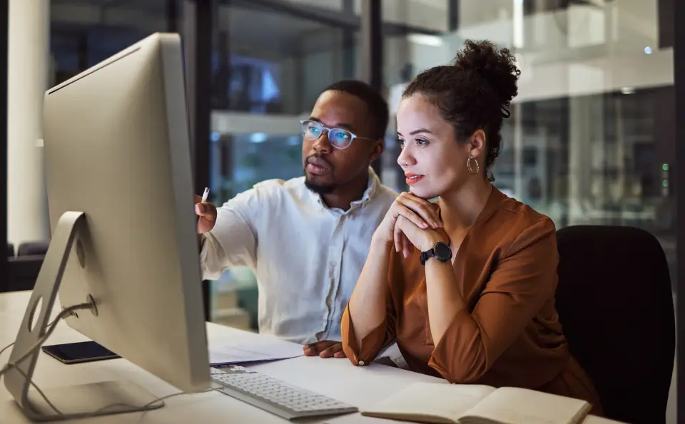 Two people collaborating at a computer.