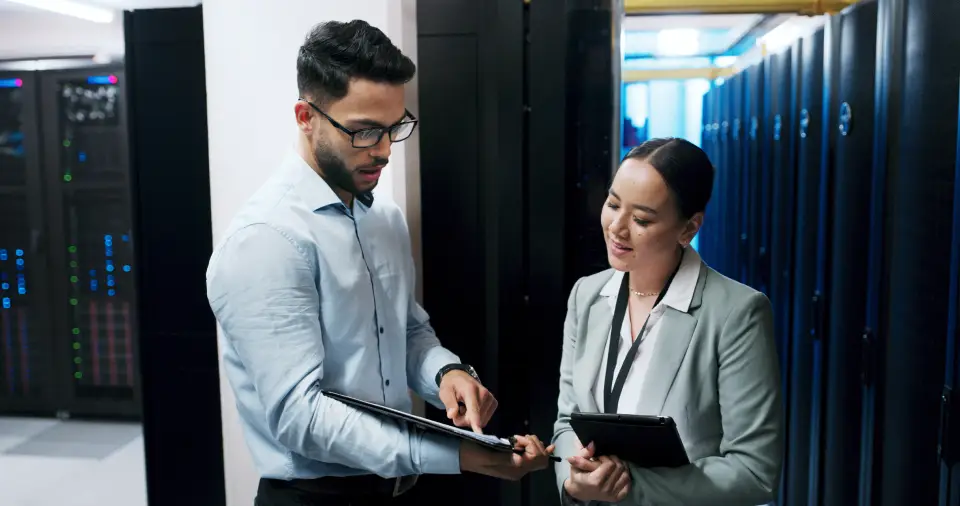 Two professionals discussing in server room